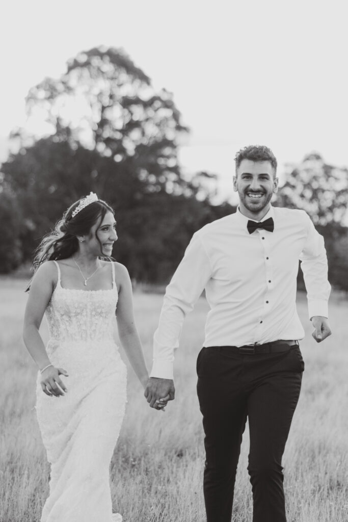 Couple getting Wedding photos at The Hayshed by Meredith Photography, black and white running to camera